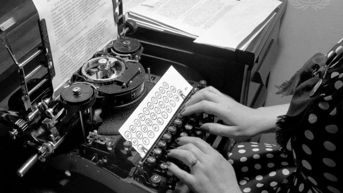 Russian-American typist working a typewriter lettered in Russian.